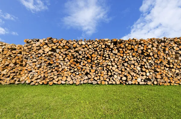 Haufen gehäckseltes Brennholz am blauen Himmel — Stockfoto