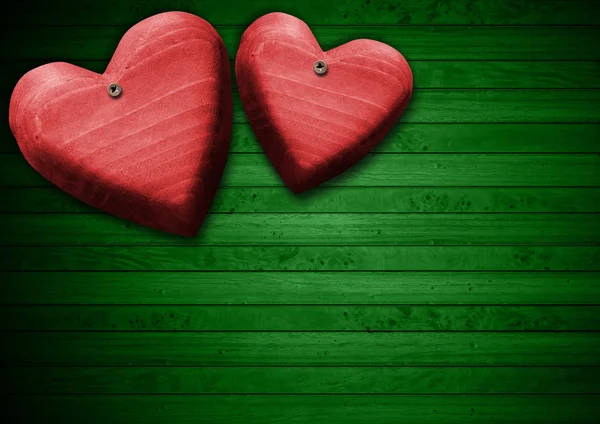 Red Wooden Hearts on Green Wood Background — Stock Photo, Image