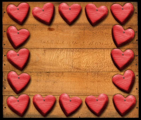 Cadre de coeurs rouges sur des planches en bois — Photo