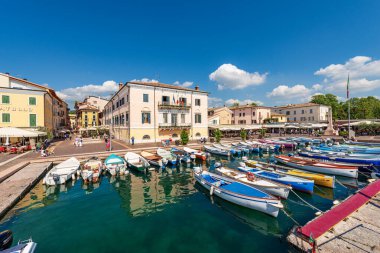 BARDOLINO, İtalya - 26 Mayıs 2021: Garda Gölü 'nün küçük limanı (Lago di Garda) balıkçı tekneleri demirli. Bardolino köyü, Verona ilindeki turizm beldesi, Veneto, İtalya, Avrupa.