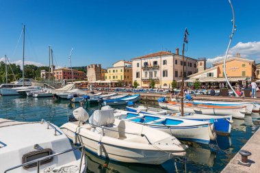 BARDOLINO, İtalya - 26 Mayıs 2021: Garda Gölü Limanı (Lago di Garda) birçok tekne demirli. Küçük Bardolino köyü, Verona ilindeki turizm beldesi, Veneto, İtalya, güney Avrupa.