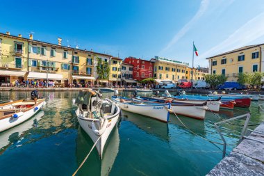 LAZISE, İtalya - 26 Mayıs 2021: Küçük Lazise köyü, Garda Gölü kıyısındaki turizm beldesi (Lago di Garda) demirlemiş küçük tekneleri olan liman. Verona ili, Veneto, İtalya, Güney Avrupa.