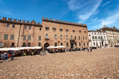 Mantua, İtalya - 9 Mayıs 2021: Şehrin ana meydanlarından biri olan Piazza Sordello 'nun tarihi merkezinde kalabalık bir restoran. Lombardy, İtalya, Avrupa. Sağdaki Piskopos Sarayı..