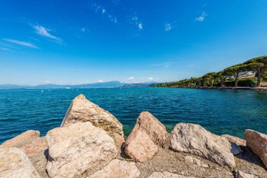 Verona ili, Veneto, İtalya, Avrupa 'daki küçük Lazise köyünün önünde yer alan Garda Gölü' nün (Lago di Garda) güzel kıyıları. Ufukta Lombardiya kıyılarında.