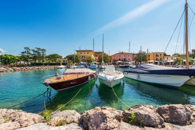 Garda Gölü kıyısında (Lago di Garda) demirlemiş çok sayıda teknesi olan küçük Cisano köyünün limanı. Bardolino belediyesi, Verona ili, Veneto, İtalya, güney Avrupa.