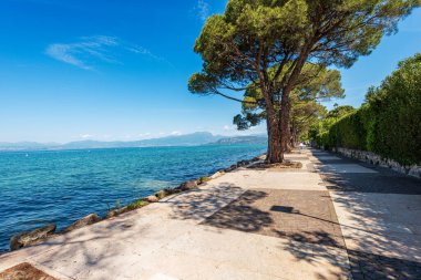 Lakeshore of Garda Gölü (Lago di Garda), Lazise köyünde bisiklet ve yaya yolu ile. Verona, Veneto, İtalya, güney Avrupa 'daki turizm beldesi. Ufukta Lombardiya kıyısı var..