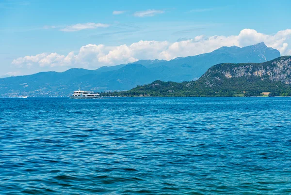 ヴィジリオの岬とモンテ ピッツォーロの山のピークを背景に ガルダ湖 Lago Garda の航行中の白いフェリー ヴェローナ州 ヴェネト州 ロンバルディア州 イタリア — ストック写真