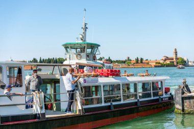 Murano adasının feribot istasyonu Punta Faro, 2 Haziran 2021 'de Venedik lagününden bir grup insanla birlikte. Arka planda, San Michele adasında. Veneto, İtalya, Avrupa.