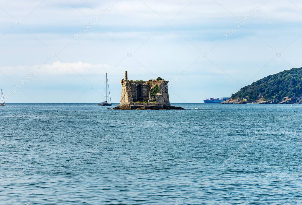 Ancient Scola Tower (Torre Scola) or of Saint John Baptist, XVII century, entrance the port of the Gulf of La Spezia, Porto Venere, Liguria, Italy, Europe. On the right the island of Palmaria.