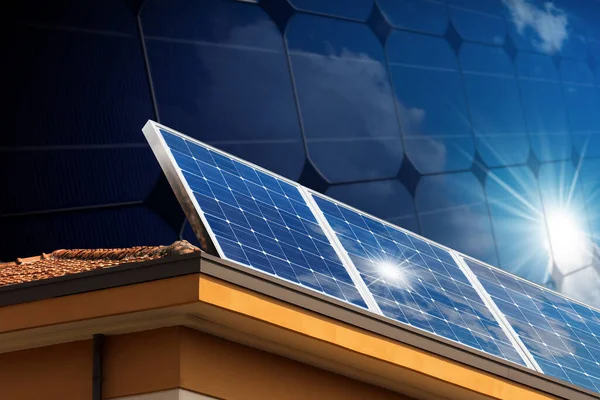 在房屋屋顶上方的一组太阳能电池板的特写 以及背景上带有太阳光的大型太阳能电池板的特写 可再生能源概念 免版税图库图片