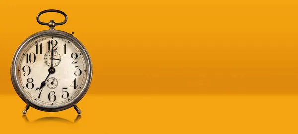 关闭橙色和黄色背景上的一个旧闹钟 带有复制空间和反射 七点钟方向 意大利 — 图库照片
