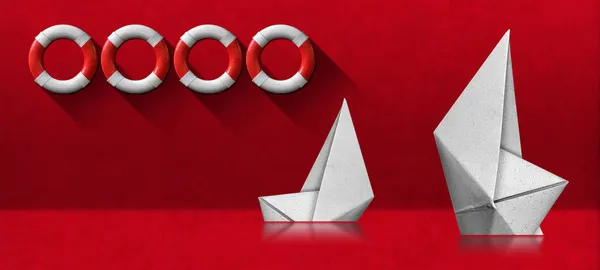 两艘白色纸船在红色背景上沉没 有四个白色和红色救生圈 — 图库照片