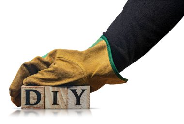 Koruyucu iş eldivenleri olan, elinde DIY (Kendin Yap) metni bulunan, ahşap bloklardan yapılmış, beyaz arka planda yansımaları ve kopyalama alanı olan el işi işçisi..