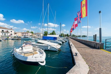 Bardolino köyünün küçük limanında küçük tekneler demirlemiş. Garda Gölü kıyısındaki turizm beldesi (Lago di Garda). Verona ili, Veneto, İtalya, Güney Avrupa.