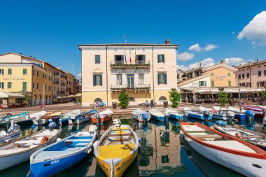BARDOLINO, İtalya - 26 Mayıs 2021: Garda Gölü 'nün küçük limanı (Lago di Garda) balıkçı tekneleri demirli. Bardolino köyü, Verona ilindeki turizm beldesi, Veneto, İtalya, Avrupa.