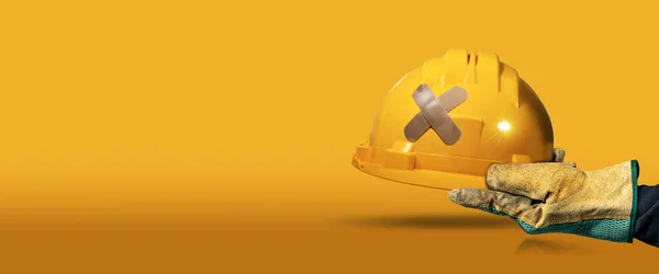 Arbeiter Mit Schutzhandschuh Der Einen Gelben Schutzhelm Mit Kreuzbandaid Klebeverband — Stockfoto