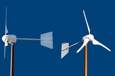 Close-up of two wind turbines isolated on a blue background. Renewable energy concept. clipart