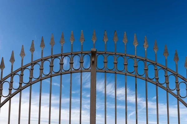 雲とコピースペースと青い空に鋭いポイントを持つ錬鉄製のゲートのクローズアップ — ストック写真