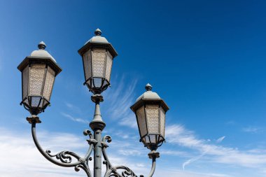 Bulutlar ve kopyalama alanı olan açık mavi gökyüzüne yakın sokak lambaları. Loggia şehir meydanı (Piazza della Loggia), Brescia şehir merkezi, Lombardy, İtalya, Güney Avrupa.