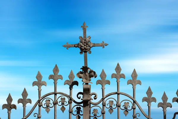 Zmačkaná Železná Brána Náboženským Křížem Ostrými Hroty Proti Rozmazané Modré — Stock fotografie