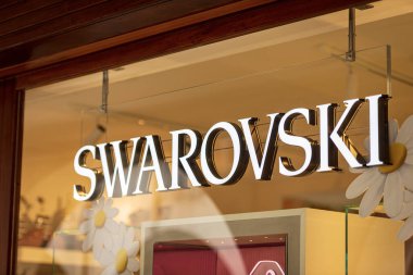 TREVISO, İtalya - 8 Nisan 2022: Treviso şehir merkezindeki lüks bir butiğin vitrininin üstündeki Swarovski kurumsal logosuna yakın çekim. Veneto, İtalya, Avrupa.