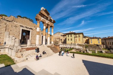 BRESCIA, İtalya - 17 Nisan 2022: Brescia şehir merkezinde turistlerle birlikte Capitolium Roma Tapınağı 'nın (Tempio Capitolino) antik kalıntıları, 73 AC, UNESCO dünya mirası sahası, Lombardiya, İtalya, Avrupa. 