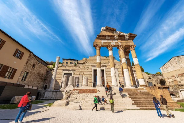 BRESCIA, İtalya - 17 Nisan 2022: Brescia şehir merkezinde turistlerle birlikte Capitolium Roma Tapınağı 'nın (Tempio Capitolino) antik kalıntıları, 73 AC, UNESCO dünya mirası sahası, Lombardiya, İtalya, Avrupa. 