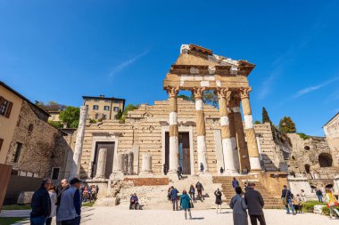 BRESCIA, İtalya - 17 Nisan 2022: Brescia şehir merkezinde turistlerle birlikte Capitolium Roma Tapınağı 'nın (Tempio Capitolino) antik kalıntıları, 73 AC, UNESCO dünya mirası sahası, Lombardiya, İtalya, Avrupa. 