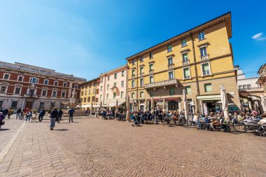 BRESCIA, ITALY - APRIL 17, 2022: Brescia downtown. The main town square called Piazza Paolo VI or Piazza del Duomo (Cathedral square) of medieval origins with many people. Lombardy, Italy, Europe.