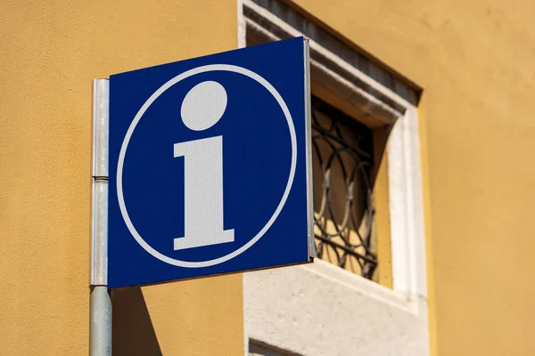 Closeup of a blue tourist information sign with the letter i, in an Italian city. Italy, Europe, Photography.