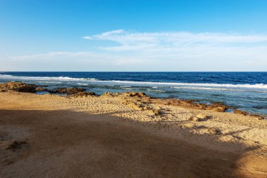 Kumsal ve Kızıldeniz 'in güzel deniz manzarası Marsa Alam, Mısır, Afrika yakınlarında. Mercan kayalıklarında ve kayalıklarda dalgalar kopuyor..