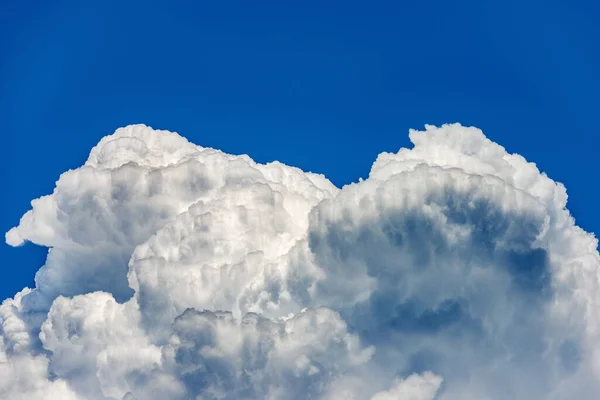 Photography of beautiful storm clouds, cumulus clouds or cumulonimbus against a clear blue sky. Full frame, sky only.