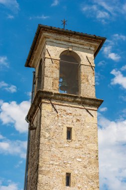 Ancient bell tower of a small church against a blue sky with clouds (Chiesa della Beata Vergine della Mercede or dell'Ancona), 1687. Spilimbergo, Pordenone, Friuli-Venezia Giulia, Italy, Europe.