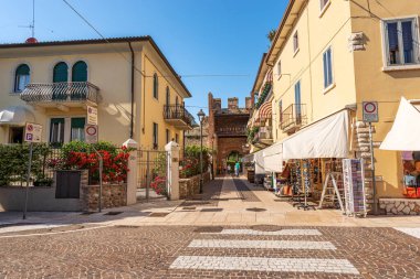 LAZISE, ITALY - 26 Mayıs 2021: Ortaçağ çevre duvarı ve Garda Gölü kıyısındaki küçük Lazise köyünün antik çentikli kulesi. Verona ili, Veneto, İtalya, Avrupa.