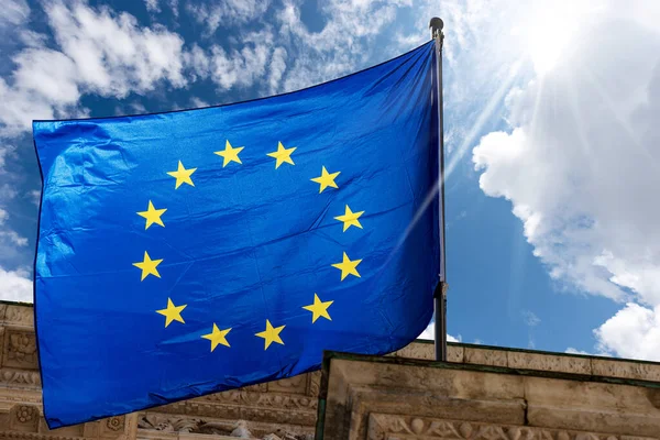 欧盟旗帜在乌云和太阳光映衬下迎风飘扬的近照 Brescia Lombardy Italy Europe — 图库照片