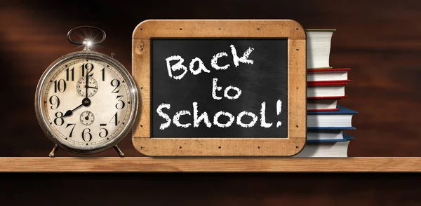 Back To School, close-up of an old alarm clock on a wooden shelf with a blackboard with wood frame and a stack of school books