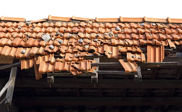 Closeup of a damaged roof with terracotta orange roof tiles (Pantiles, Coppo in Italian language). Isolated on white background, photography.