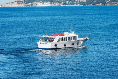 LA SPEZIA, ITALY - 9 Temmuz 2022: Porto Venere veya Portovenere, La Spezia Körfezi, Liguria, İtalya, Avrupa 'nın önündeki mavi Akdeniz' de hareket halindeki bazı turistlerle küçük feribot.