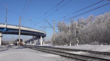 Rusya, Moskova bölgesi, 2022 Şubat 05. Yolcu treni Moskova 'dan bir yol köprüsünün altından geçiyor. Kış güneşli gün