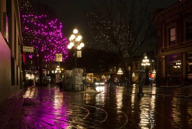 Vancouver British Columbia, Kanada. Gece, yağmurdan sonra şehrin ışığını aydınlattı. Şehir merkezindeki eski cadde binaları, çelenkler ve arabalar. Gece arkaplanı