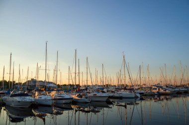 İnanılmaz bir gün batımı, limanda tekneler, gün batımında göl koyunda yatlar. Yaz zamanı, sakin su.  