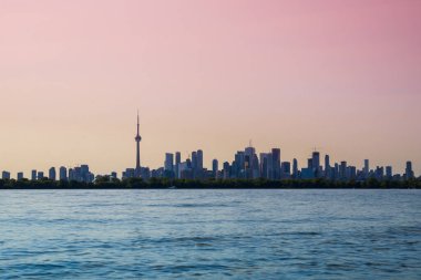 Toronto gökdelenli şehir manzarası, sakin göl suyu. Kentsel ufuk çizgisi geçmişi. Akşam vakti, gün batımı