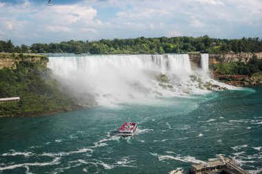 Bulutlu bir günde Kanada 'dan American Falls manzarası. Mavi nehir ve kayalık sahilli şelale. Yaz. Gezgin gemi turistlerle Niagara Şelalesi, Ontario,