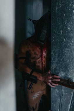 Kanlı adam maskeli zombi canavarın görüntüsü karanlıkta saklanıyor. Cadılar Bayramı konsepti.