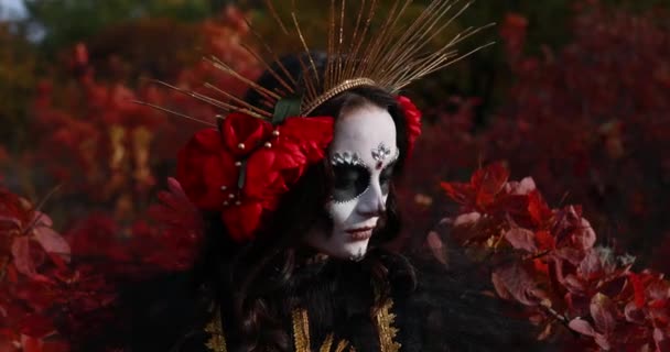 在秋天的森林背景下 身穿黑色死亡服装的年轻女子的画像 头像是糖衣和红玫瑰 死亡日或万圣节的概念 — 图库视频影像
