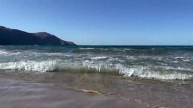 Yunanistan 'ın Girit adasındaki sahil şeridinde dalgaların dalgalanması, köpük ve su sıçraması üzerine yakın görüş.