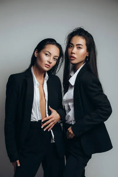Zwei Junge Brünette Frauen Posieren Studio Stehend Schwarzen Anzügen — Stockfoto