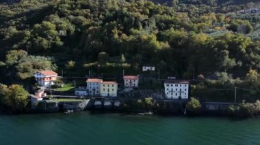 İtalyan gölünün su yüzeyinden güzel drone manzarası Como 'dan Bellano' ya sahil boyunca ve ormanlı tepeler boyunca.