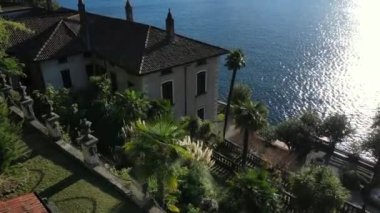 Güzel drone manzaralı bir villa göl kenarında bahçeli Como kıyısı su arka planında.