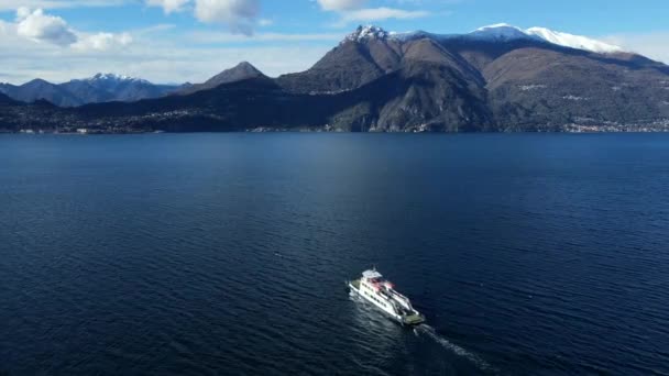 イタリアの雪のアルプスの峰を背景にコモ湖に浮かぶ渡し船のドローン撮影 — ストック動画